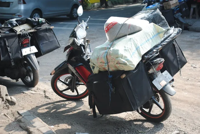 รถมอเตอร์ไซค์บรรทุกสัมภาระจำนวนมากที่ท้ายรถ